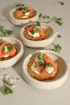 four small bowls with food in them on a table