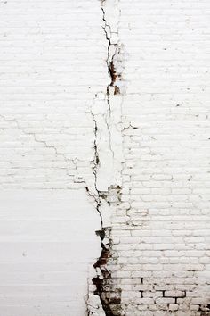 a white brick wall with cracks in it