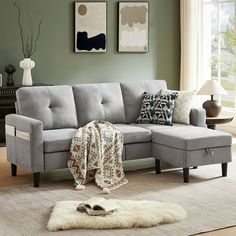 a living room with a gray couch and white rugs on the floor in front of a window