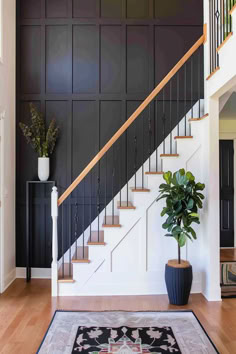 Modern staircase with black board and batten accent wall Accent Wall Ideas Staircase, Black Wall On Staircase, Staircase Wall Board And Batten, Dark Accent Wall Staircase, Entry Stairs Wallpaper, Stair Wall Board And Batten, Open Staircase Accent Wall, Stairway Wall Treatments, Wall Below Stairs Decor