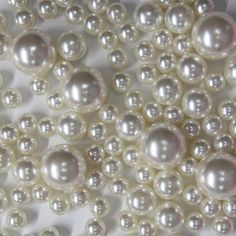 white pearls are arranged in rows on a white surface