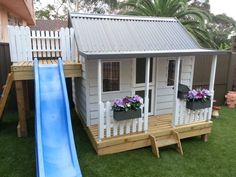 a small house with a slide in the yard