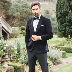 a man in a tuxedo poses for the camera