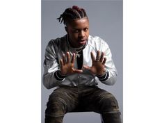 a man with dreadlocks sitting on top of a chair wearing a jacket and tie