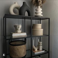 a shelf with vases, books and other decorative items on it's sides