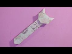 an origami tie with the words happy birthday written on it, against a pink background