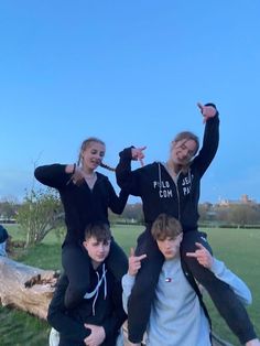 four young people posing for the camera with their hands in the air