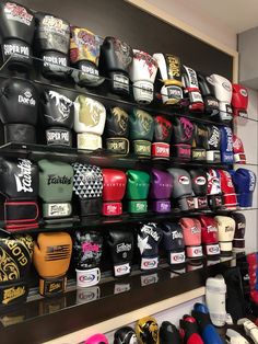 many different types of hats are on display in a room with black and white walls