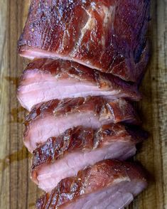 sliced ham sitting on top of a wooden cutting board