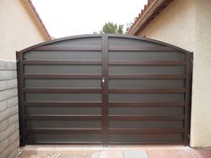 a large brown gate in front of a house