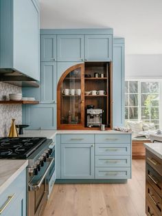 a kitchen with blue cabinets and wooden floors