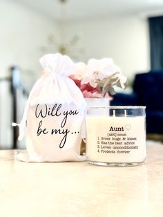 a white candle sitting on top of a table next to a bag