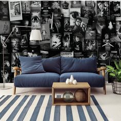 a blue couch sitting in front of a black and white wall with pictures on it