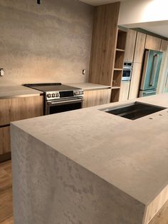 a kitchen with an island counter top next to a stove and oven in the middle