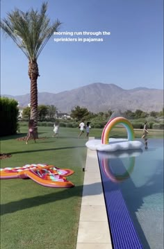 an inflatable pool is next to a palm tree and some people are playing