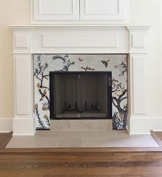 the fireplace is decorated with birds and flowers on it's mantle, along with white paneling