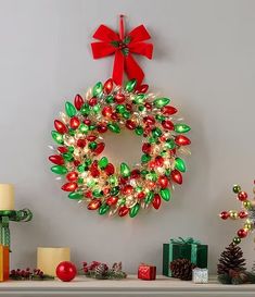 a christmas wreath is hanging on the wall next to candles and other holiday decor items