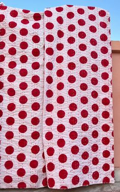 two red and white bedspreads with circles on them