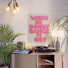 a poster that says when in doubt dance out on the wall next to a record player