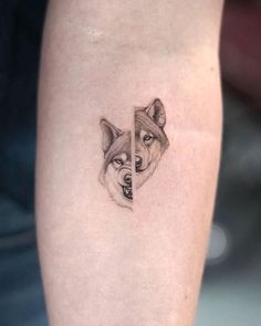 a small tattoo on the leg of a woman with a wolf's head in it