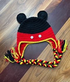 a crocheted mickey mouse hat on top of a wooden floor