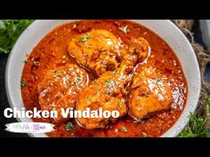 chicken vindaloo in a white bowl with garnishes and parsley