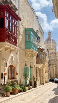 an alley way with buildings and potted plants