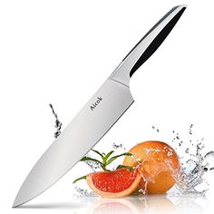 a large knife that is on top of some oranges and water splashing around it