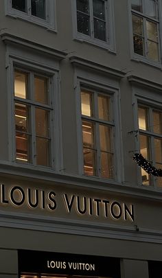 the storefront of louis vuitton is lit up at night with its lights on