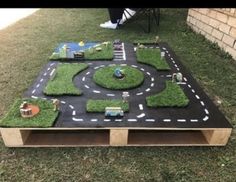 an outdoor play area made out of grass and toys on top of a wooden table