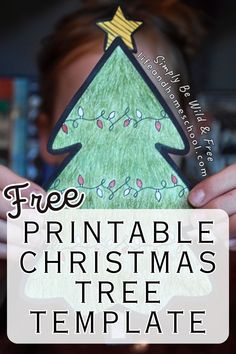 a person holding up a paper christmas tree with the text free printable christmas tree template