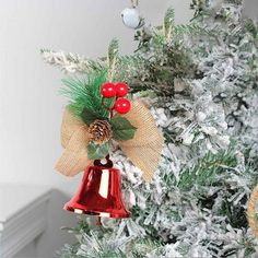 a christmas ornament hanging from the side of a tree with red berries on it