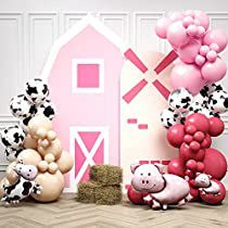 there are many balloons and farm animals in front of the barn with pink accents on it