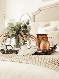 a tray with flowers and candles on a bed