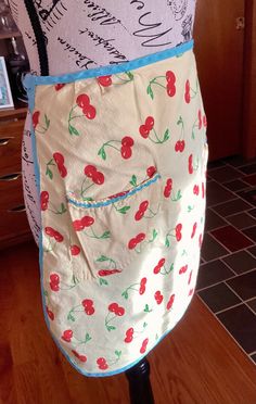 an apron with cherries on it sitting on a table