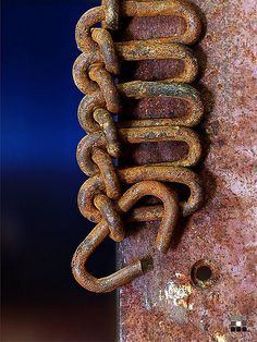 an old rusty chain hanging on the side of a building