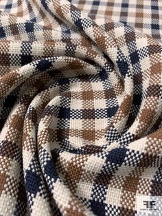 a close up view of a checkered fabric in brown, white and blue colors