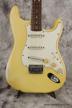 a yellow electric guitar sitting on top of a table