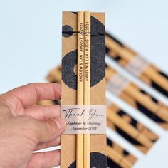 a person holding two wooden chopsticks in their hand