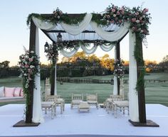 an outdoor wedding set up with white and pink flowers