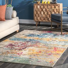 a living room area with blue walls and colorful rugs on the hardwood flooring