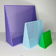 three different colored pieces of plastic on a white surface