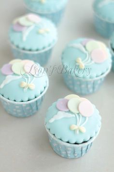 blue cupcakes with white and pink decorations on them