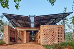 a brick building with a metal roof and wooden walkway leading up to the top floor