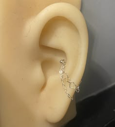 a close up view of a fake ear with chain attached to the back of it