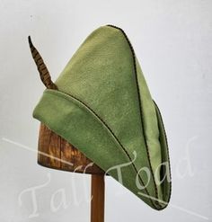 a green hat on top of a wooden stand