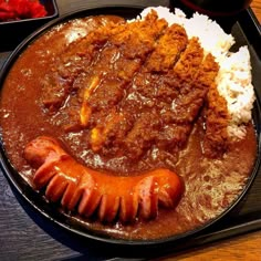 a plate with meat, rice and gravy on it