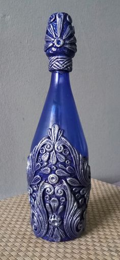 a blue vase sitting on top of a table next to a white and gray wall