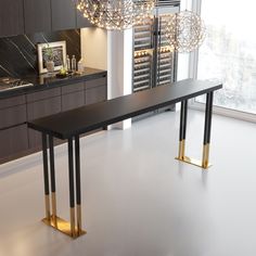 a black and gold dining table in a modern kitchen with chandelier hanging from the ceiling