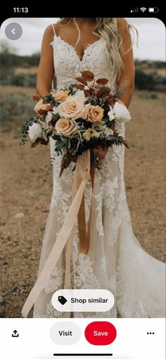 a woman in a wedding dress holding a bridal bouquet with roses and greenery